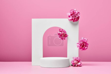 Photo for White podium with pink flowers and elegant arch isolated on pastel pink background. stage for presentation cosmetic or beauty product - Royalty Free Image