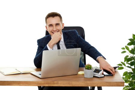 Photo for Young happy businessman sitting on chair at table and resting, using laptop - Royalty Free Image
