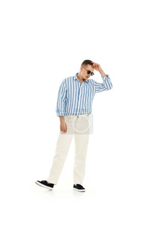 Photo for Smiling happy confident man in sunglasses and blue striped shirt standing isolated on white background. full length. - Royalty Free Image