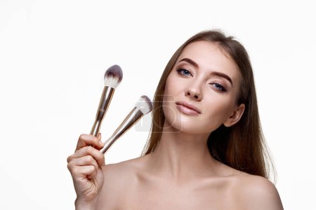 Photo for Attractive woman with make-up brush for powder isolated on white background - Royalty Free Image