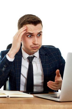 Foto de Hombre de negocios molesto usando el ordenador portátil, sentado en la silla en el escritorio, teniendo problemas para pensar en los problemas en la oficina - Imagen libre de derechos