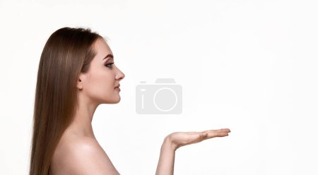 Téléchargez les photos : Jolie jeune femme tenant sur bras ouverts l'espace de copie isolé sur fond blanc. thérapie faciale - en image libre de droit
