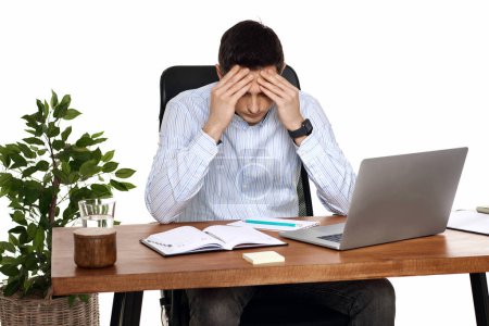 Foto de Triste hombre tiene un dolor de cabeza, utilizando el ordenador portátil en la oficina - Imagen libre de derechos