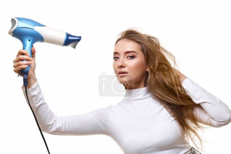 Photo for Portrait of attractive cheerful girl drying long hair isolated on white background - Royalty Free Image