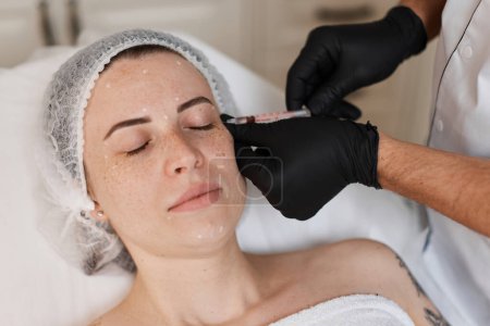 Téléchargez les photos : Femme reçoit une injection cosmétique de botox dans le visage. Femme dans un salon de beauté. chirurgie plastique. - en image libre de droit