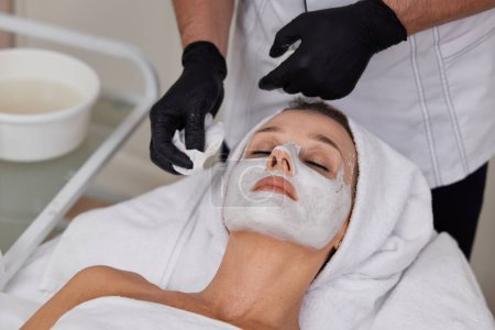 Téléchargez les photos : Gros plan de l'esthéticienne nettoie la peau de la femme. Nettoyage parfait, soin visage. - en image libre de droit