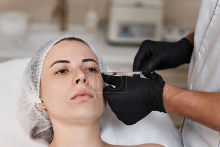 Foto de Mujer recibe inyección cosmética de botox en la cara. Mujer en el salón de belleza. cirugía plástica. - Imagen libre de derechos