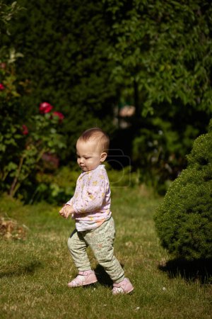 Foto de Linda niña corriendo en el jardín en el día de verano - Imagen libre de derechos