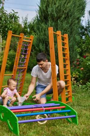 Foto de Papá con hija niña colecciona complejo de deportes caseros de madera al aire libre. proceso de montaje - Imagen libre de derechos