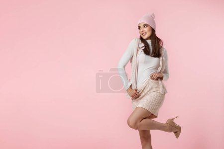 Téléchargez les photos : Joyeux ludique jeune femme en chapeau rose, chemise et jupe dansant isolé sur fond rose pastel. - en image libre de droit