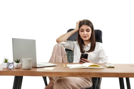 Téléchargez les photos : Belle gestionnaire heureuse femme travaillant avec ordinateur portable et en utilisant le téléphone sur fond blanc - en image libre de droit