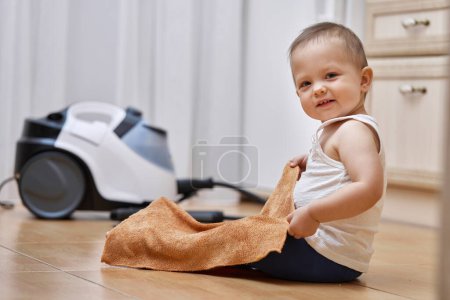 Téléchargez les photos : Petite fille bébé avec un chiffon laver le sol carrelé, mignon petit assistant - en image libre de droit