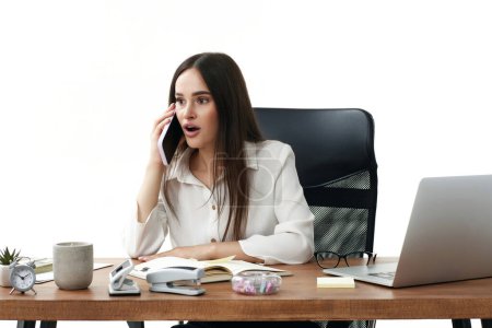 Téléchargez les photos : Surpris choqué femme d'affaires travaillant avec ordinateur portable et ayant une conversation téléphonique avec le client - en image libre de droit