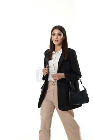 Téléchargez les photos : Belle dame avec sac en blazer noir et pantalon beige isolé sur fond blanc - en image libre de droit