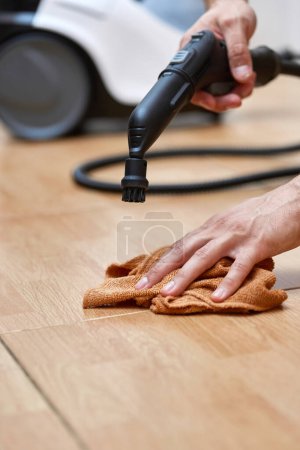 Foto de Mano masculina con limpieza profesional generador de vapor limpieza suelo de baldosas, desinfección del hogar - Imagen libre de derechos