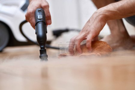 Foto de Mano masculina con limpieza profesional generador de vapor limpieza suelo de baldosas, desinfección del hogar - Imagen libre de derechos
