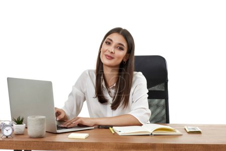 Téléchargez les photos : Belle gestionnaire féminin en utilisant un ordinateur portable pour le travail en ligne à table sur fond blanc - en image libre de droit