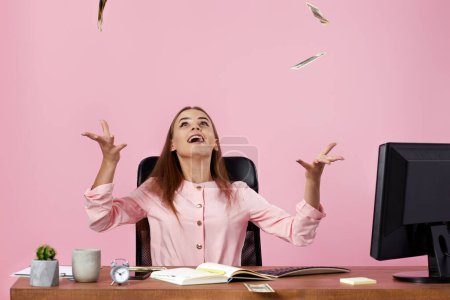 Téléchargez les photos : Jolie femme d'affaires jetant de l'argent sur fond rose. les billets volent dans les airs - en image libre de droit
