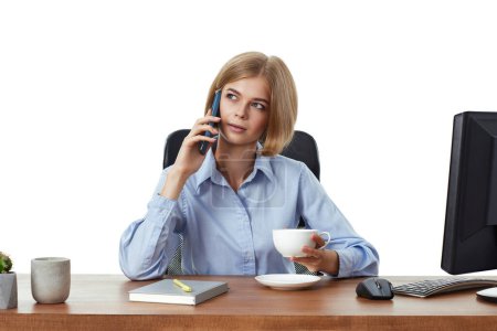 Foto de Hermosa mujer de negocios rubia usando el teléfono, beber café en la oficina - Imagen libre de derechos