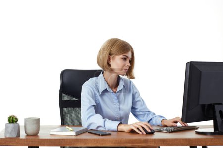 Téléchargez les photos : Belle gestionnaire femme en utilisant l'ordinateur pour le travail en ligne au bureau - en image libre de droit