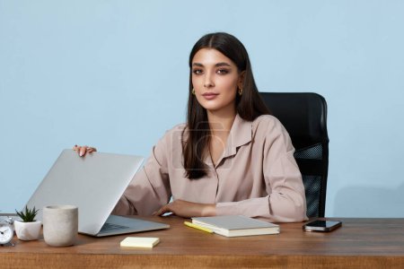 Téléchargez les photos : Jeune femme d'affaires utilisant un ordinateur portable pour le travail en ligne à la table - en image libre de droit