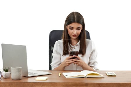 Téléchargez les photos : Belle gestionnaire heureuse femme travaillant avec ordinateur portable et en utilisant le téléphone sur fond blanc - en image libre de droit