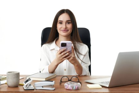 Téléchargez les photos : Attrayant souriant femme d'affaires en utilisant le téléphone dans le bureau - en image libre de droit