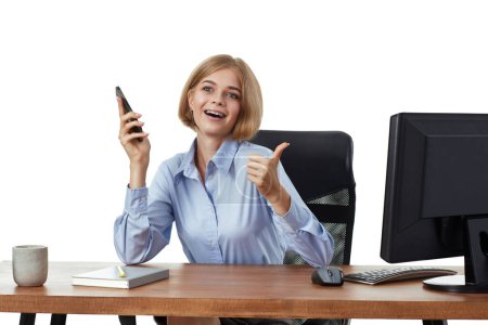 Foto de Mujer de negocios bastante rubia usando el teléfono y mostrando los pulgares hacia arriba gesto en la oficina - Imagen libre de derechos