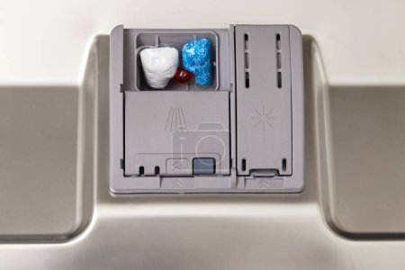 Photo for Dishwasher compartments for detergents with dishwasher tablet inside. close-up. - Royalty Free Image