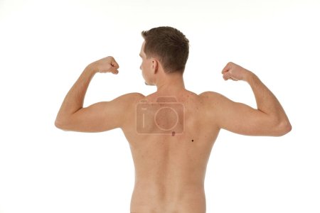 Foto de Joven mostrando su bíceps sobre fondo blanco. Vista trasera. forma del cuerpo perfecto - Imagen libre de derechos