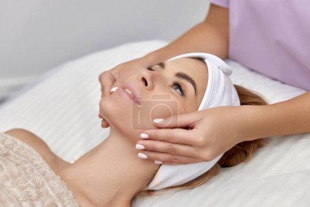 Photo for Beautiful woman getting face massage treatment in beauty salon. Skin care. - Royalty Free Image