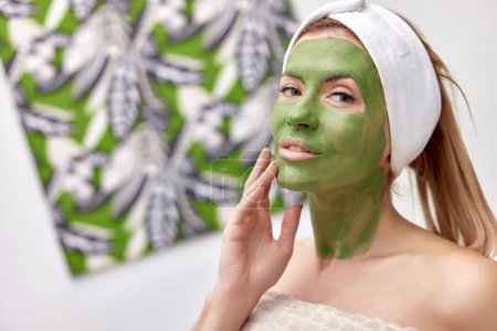 Téléchargez les photos : Belle femme avec masque en alginate vert sur le visage - en image libre de droit