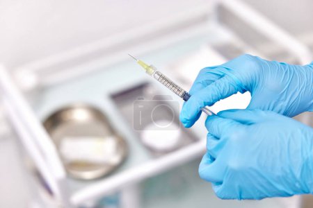 Photo for Physician hand in blue gloves with syringe for injection - Royalty Free Image