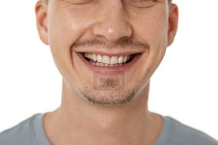 Téléchargez les photos : Bouche et les dents de l'homme souriant sur fond de studio. visage masculin avec des dents propres - en image libre de droit