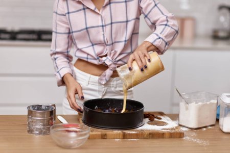 Téléchargez les photos : Femme fait la pâte pour la tarte dans la cuisine moderne - en image libre de droit