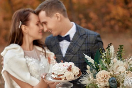 Photo for Bride and groom on the nature in autumn . wedding couple with cake outdoor - Royalty Free Image