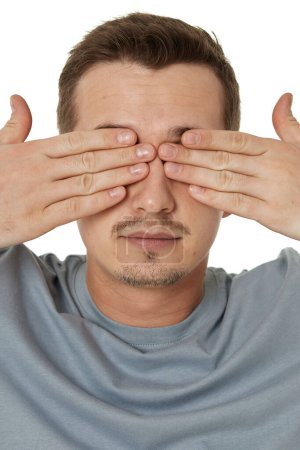 Téléchargez les photos : Homme couvrant les yeux avec les mains sur fond blanc - en image libre de droit
