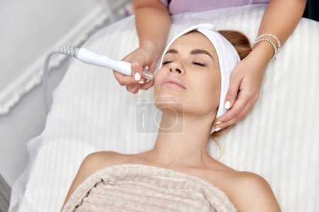Foto de Cosmetólogo procedimiento de fabricación microdermoabrasión en la cara en el salón de belleza. cuidado profesional de la piel - Imagen libre de derechos