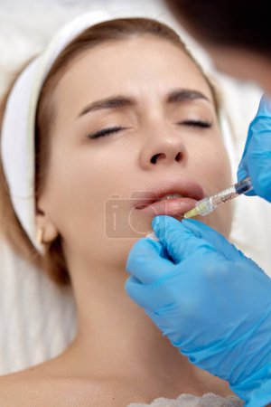 Foto de Cosmetólogo hace inyecciones para agrandar los labios de la mujer hermosa. procedimiento labio aumento - Imagen libre de derechos