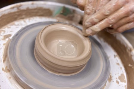 Téléchargez les photos : Mains masculines faisant tasse en céramique sur roue de poterie, Gros plan - en image libre de droit