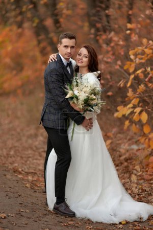 Téléchargez les photos : Belle mariée sensuelle en robe de mariée blanche et marié debout en plein air sur fond naturel - en image libre de droit