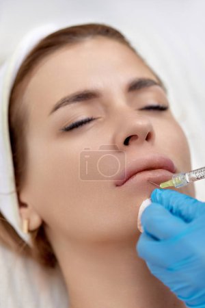 Foto de Cosmetólogo hace inyecciones para agrandar los labios de la mujer hermosa. Inyección de relleno de labios - Imagen libre de derechos