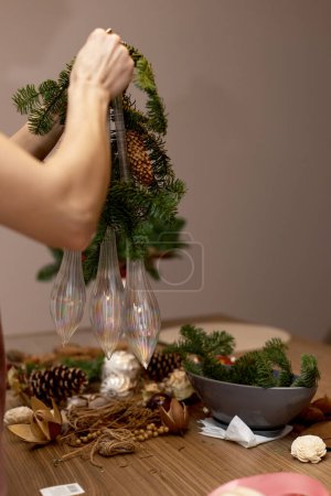 Photo for Woman making Christmas arrangement with fir branches. craft handmade decor. - Royalty Free Image