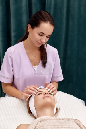 Photo for Beautiful woman getting face massage treatment in beauty salon. Skin care. - Royalty Free Image