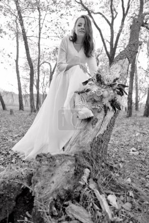 Photo for Beautiful bride holding wedding autumn bouquet in nature. black and white - Royalty Free Image