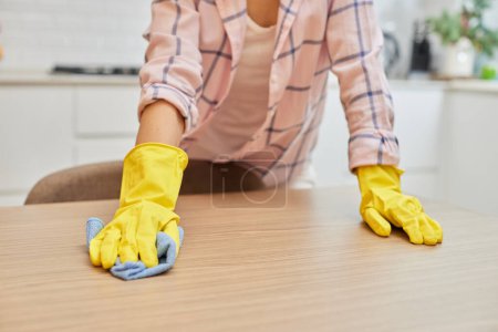 Photo for Female hands cleaning and wiping wooden table with microfiber cloth. close-up. Housekeeping - Royalty Free Image