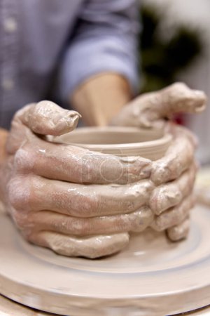 Photo for Male hands making ceramic cup on pottery wheel, Close-up - Royalty Free Image