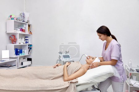 Foto de Cosmetólogo haciendo procedimiento antienvejecimiento en salón de belleza - Imagen libre de derechos
