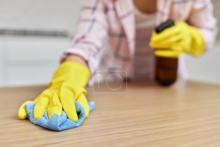 Foto de Manos femeninas limpiando y limpiando mesa de madera con paño de microfibra. Primer plano. Servicio de limpieza - Imagen libre de derechos
