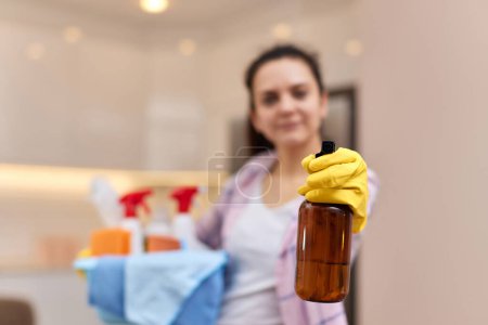 Foto de Mujer en guantes protectores de goma de color amarillo rociando detergente y sosteniendo cubo con herramientas de limpieza. tareas de la casa. espacio de copia - Imagen libre de derechos